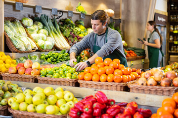 Supermarket employee will lay out ripe fruits and vegetables on the counter