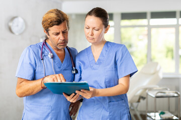 Two doctors are carefully examining the patient medical history