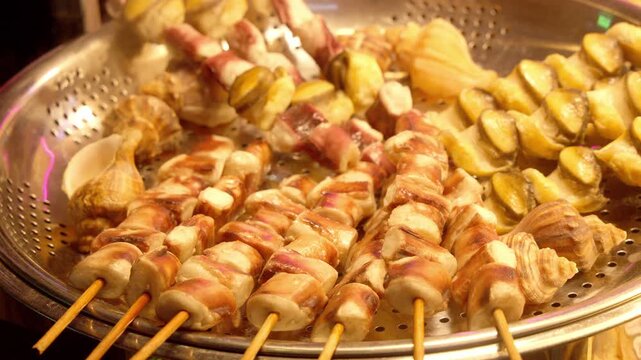 Steaming seafood skewers and shellfish for sale at a Korean street food stall