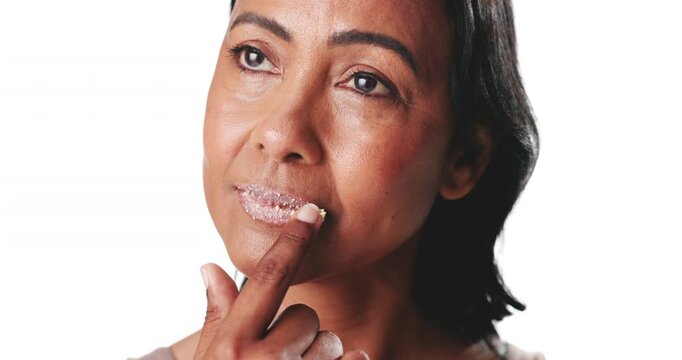 Beauty, face and lip scrub with woman in studio to apply product for protection or wellness. Aesthetic, lips and sugar with mature person thinking on white background for cosmetics or skincare