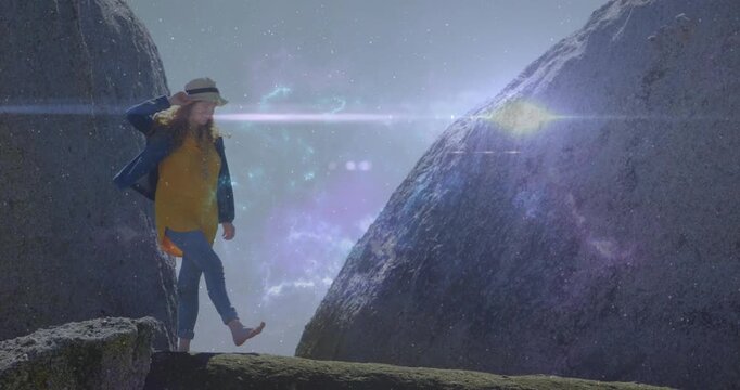 Woman stepping along ledge after gazing ahead, technology adding star field lens flare