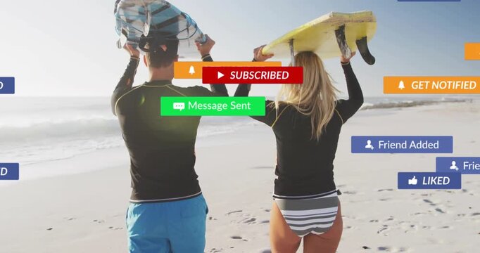 Couple walking onto beach carrying surfboards as animated social media prompts appearing and fading