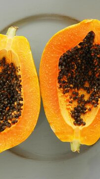 Top view of ripe half cut papaya. Rotating. Vertical footage