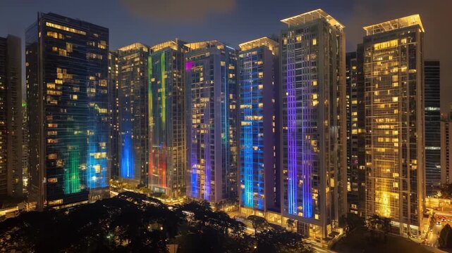 Vibrant laser ads beam onto highrise buildings in a bustling cityscape turning architectural surfaces into glowing canvases of creative commercial messaging.