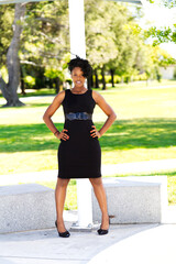Young African American Woman Standing In Black Dress Outdoors