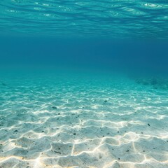 Underwater close-up of the deep ocean floor. Textured marine sand and small rocks are visible beneath clear, calm, blue water with gentle light shafts ,peaceful ,stone ,sand