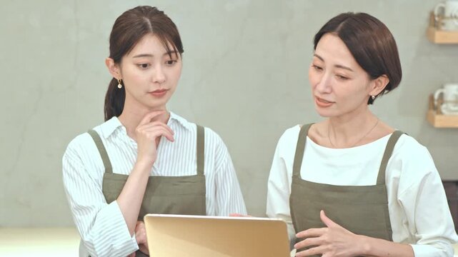 カフェで話すエプロンをつけた女性