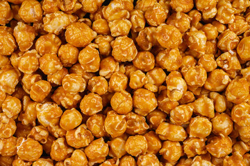 Close-up of golden caramel popcorn in full frame. Sweet, crunchy snack with glossy caramel coating. Perfect for dessert menus, packaging design, food blogs, and movie night promotions.