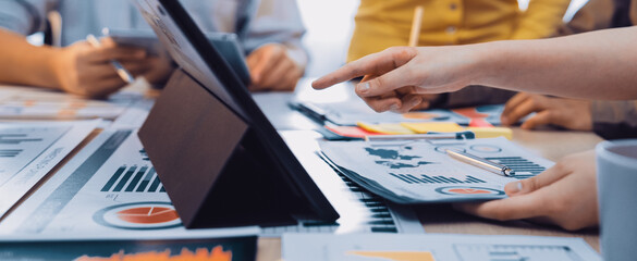 A dynamic office scene showcasing a diverse group of professionals engaged in a collaborative meeting. Focused on charts, reports, and digital devices for effective data analysis. SACTR