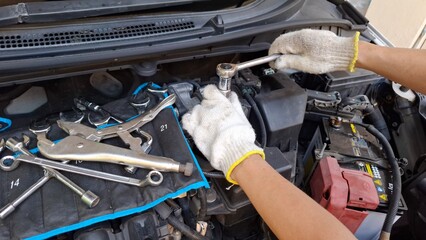 A professional car mechanic in service is inspecting a car in a service center.
