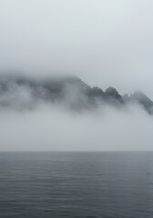 Obraz premium Thick gray fog rolls heavily over the cold, vast expanse of ocean water, creating a mysterious, isolated, and chilling seascape scene ,dense ,natural ,expanse