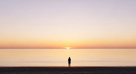 A lone figure gazes at a vibrant sunset over a tranquil, expansive body of water