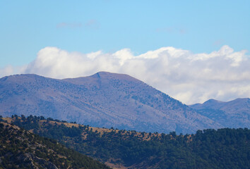 Fototapeta premium A beautiful landscape of rolling hills and mountains covered in arid vegetation under a clear blue sky on a sunny day in Turkey