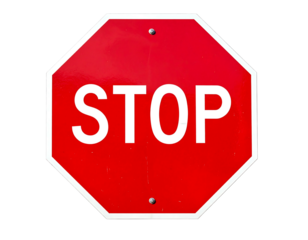 Red octagon sign with white "STOP" against black. Shows texture & slight wear from outdoor exposure
