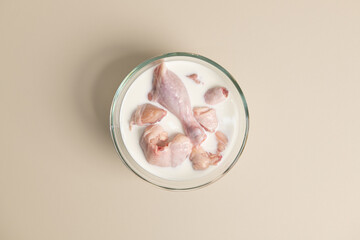 Raw Chicken Pieces Soaking in Milk in a Glass Bowl