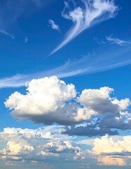 Bright, airy image of a vibrant blue sky dotted with fluffy white clouds
