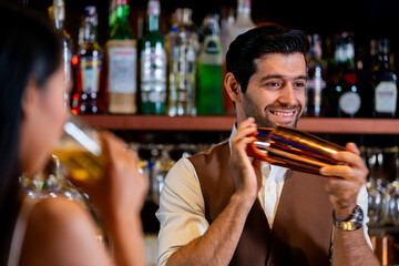 A charismatic bartender or mixologist smiles at a customer while preparing a craft cocktail with a shaker A concept for the hospitality industry and expert service