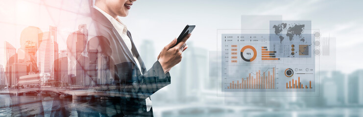Modern business professional engages with smartphone, surrounded by financial analytics graphics...