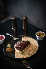 Gourmet Sliced Steak with Creamy Sauce and Mashed Potatoes on a Dark Table