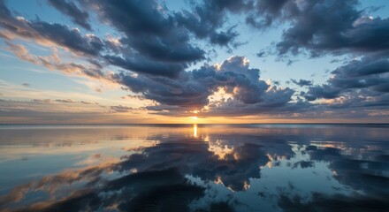 Fototapeta premium Serene seascape featuring dramatic cloud formations reflected perfectly on the smooth, glassy surface of the still water below ,outdoor ,water ,open