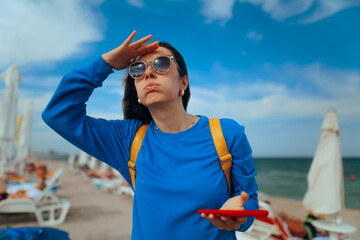 Disoriented Woman Holding her Smartphone at the Beach. Lost person trying to find a location using her phone 