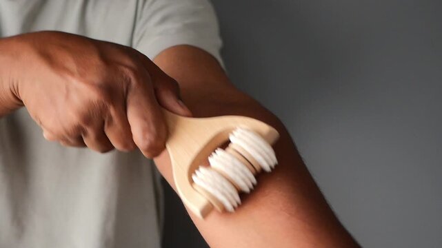 Massaging arm with a wooden roller tool for relaxation