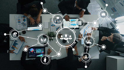 A top view of a diverse team engaged in collaborative analysis of data on digital devices, showcasing vibrant charts and innovative ideas in a professional office setting. Amity