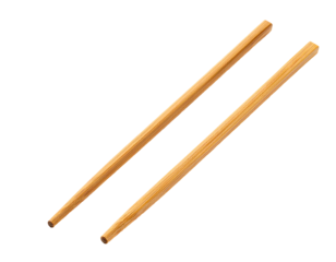 Pair of light brown chopsticks resting diagonally on a solid black background, slightly overlapping each other
