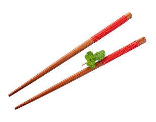 Pair of wooden chopsticks with red wrap, holding a sprig of fresh green mint, isolated on a black background
