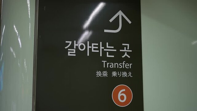 Subway signage in multiple languages indicating a transfer point in Seoul, South Korea