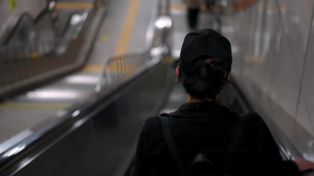 Woman riding down an escalator in a Seoul subway station