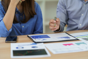 Obraz premium Businesspeople discussing financial charts and graphs during a meeting, analyzing market data for planning and strategy