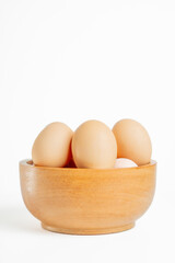 Chicken eggs on the wooden bowl. Isolated eggs on white background