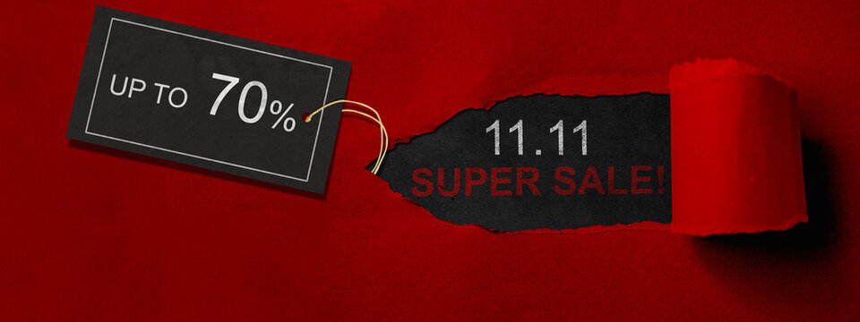 Top view of red ripped paper and text of 11.11 super sale with up to 70% text on the label tag. Copy space. Flash sale concept