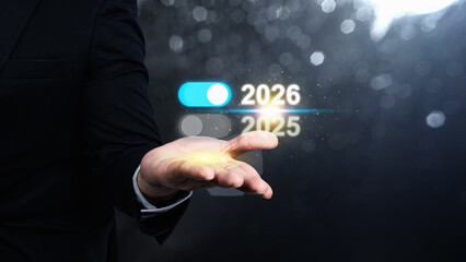 Business hand showing the year 2026 above 2025 on a virtual screen. Happy New Year concept or Celebration