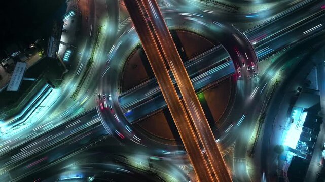 Hyperlapse time-lapse of car traffic transportation above circle roundabout road in Asian city. Drone aerial view fly in expressway circle, high angle. Public transport or commuter city life concept