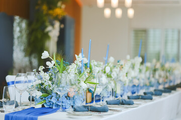 Elegant table setting for festive dining with wine glasses, plates, flowers, candles
