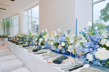 Elegant table setting for festive dining with wine glasses, plates, flowers, candles