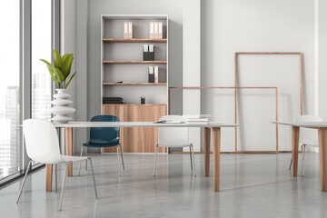 Contemporary office interior with minimalist furniture and bookshelves, rendered in 3D style, set against a bright urban background, concept of workspace. 3D Rendering.
