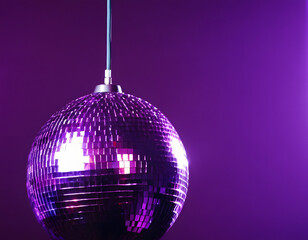 Obraz premium The party lights the disco ball with a purple background. A disco ball on a purple.
