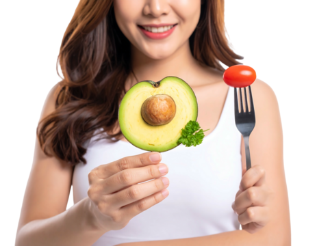 Smiling woman holds avocado half and tomato on fork, against dark backdrop. Healthy eating concept - Powered by Adobe