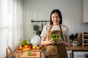 Asian young woman cooking healthy foods in kitchen in morning at home. 