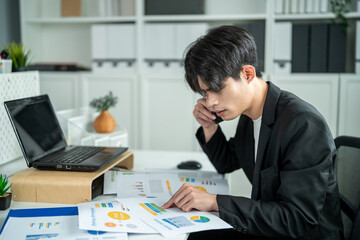 Obraz premium Asian busy businessman talking phone and using laptop working in office. 