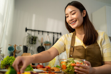 Asian young woman cooking healthy foods in kitchen in morning at home. 