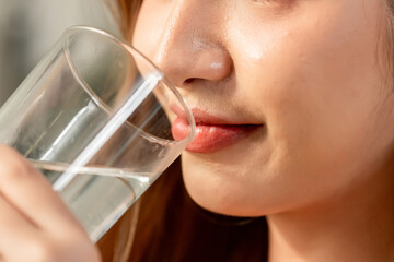 Close up lip of woman drink a glass of water in kitchen at home. 