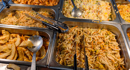soybean noodles and cantonese rice in an asian restaurant with many trays of hot food