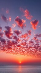 Naklejka premium Dramatic Fiery Orange Clouds Glow During Golden Hour Sunset Over Calm Ocean Reflecting Sunlight