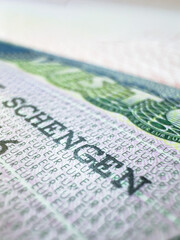 Obraz premium Schengen Visa in passport for world travel, EU visa for Italy, Immigration to England, illegal migrants, tour, airport, customs, news, closed borders, nationality. Macro photo. High quality photo