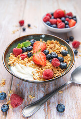 Healthy breakfast bowl with granola, yogurt and fresh berries