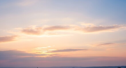 Naklejka premium Gentle morning sky with soft clouds glowing in the warm light of the rising sun creating a peaceful background
